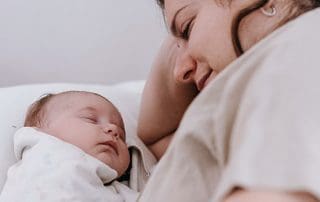 newborn baby and mom on bed