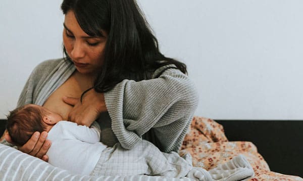 Mother having breastfeeding pain with her baby