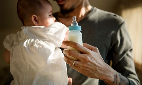 partner giving baby a bottle