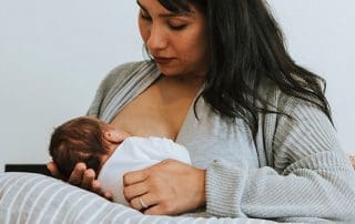 woman breastfeeding a baby with D-MER