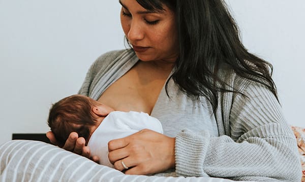 woman breastfeeding a baby with D-MER