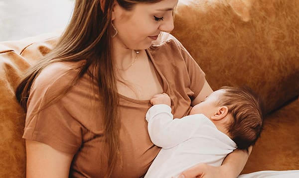 woman breastfeeding baby wondering how long should breastfeeding take