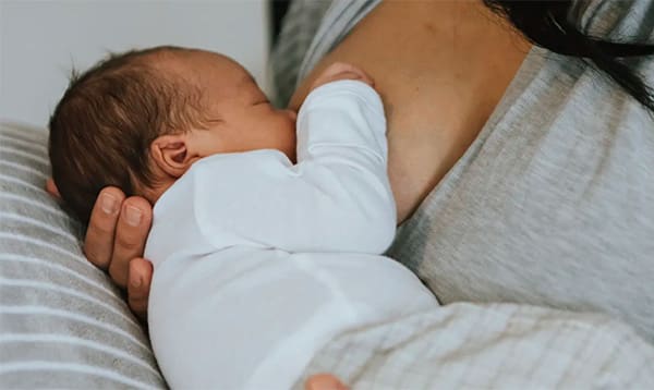 woman breastfeeding infant wanting to increase milk supply