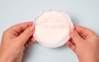 Woman holding breast pad for leaking milk