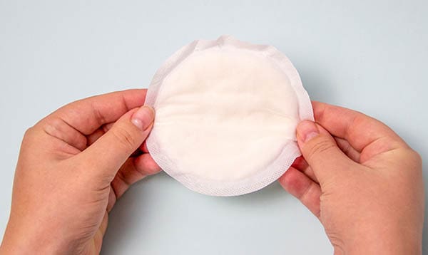 Woman holding breast pad for leaking milk