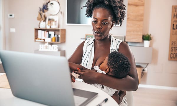 mother breastfeeding while working from home