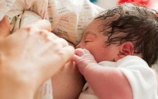 newborn baby getting colostrum milk from mother