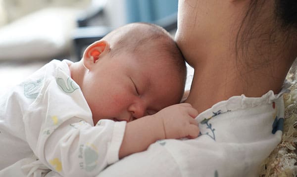 mother with baby trying to decide the best baby bottle