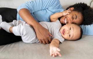 mother learning how to play with newborn baby