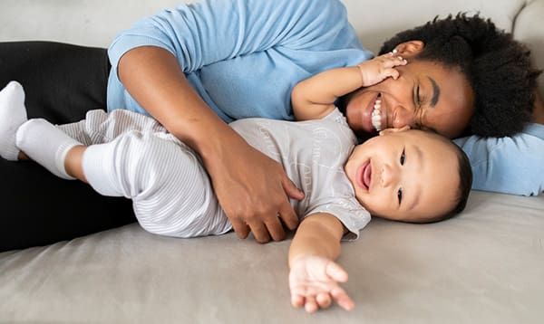 mother learning how to play with newborn baby