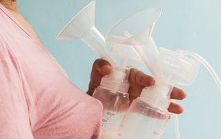 Woman holding breast pumps - blood in breastmilk how to guide