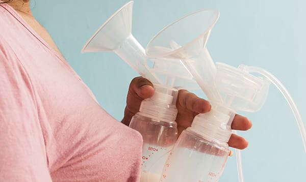 Woman holding breast pumps - blood in breastmilk how to guide