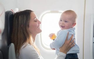 woman traveling on an airplane with a happy baby