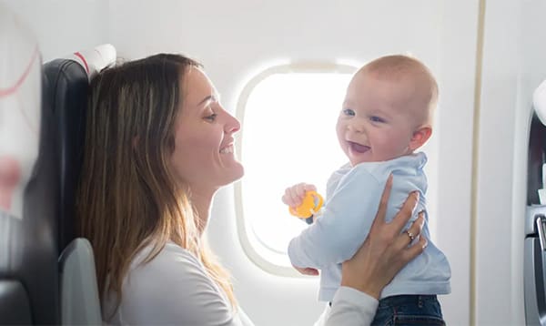 woman traveling on an airplane with a happy baby