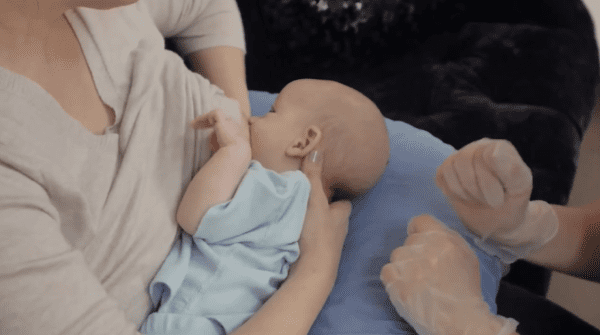 Breastfeeding Success' IBCLC helping a new mom with the cross-cradle breastfeeding position