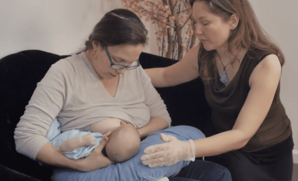 Breastfeeding Success' IBCLC helping a new mom with the football hold breastfeeding positio