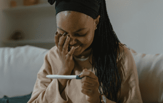 Person holding a pregnancy test, relevant to prenatal care in the first trimester.